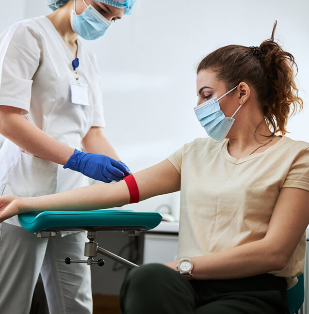 Phlebotomist drawing blood from patient 