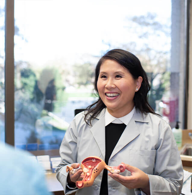 female obgyn holding a uterus structure