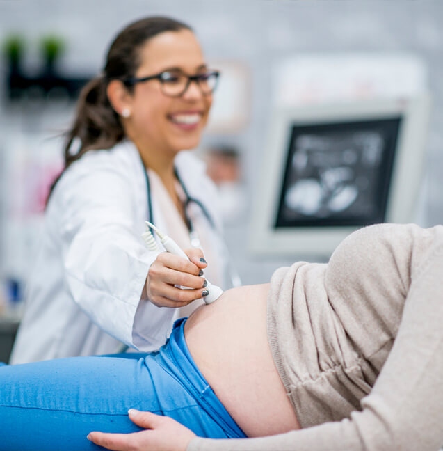 ultrasound technician using doppler ultrasound on pregnant woman